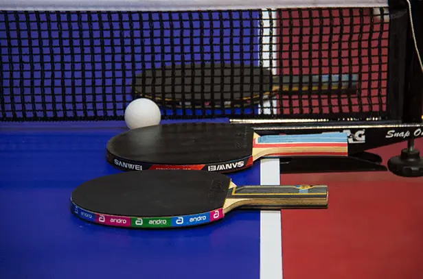 3 table tennis rackets on ping pong table